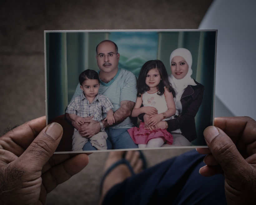 Tarek,holds a photo of the family. In the photo, taken in the United Arab Emirates, Tarek carries Saed, while Sohad, Sara’s mom, carries her.