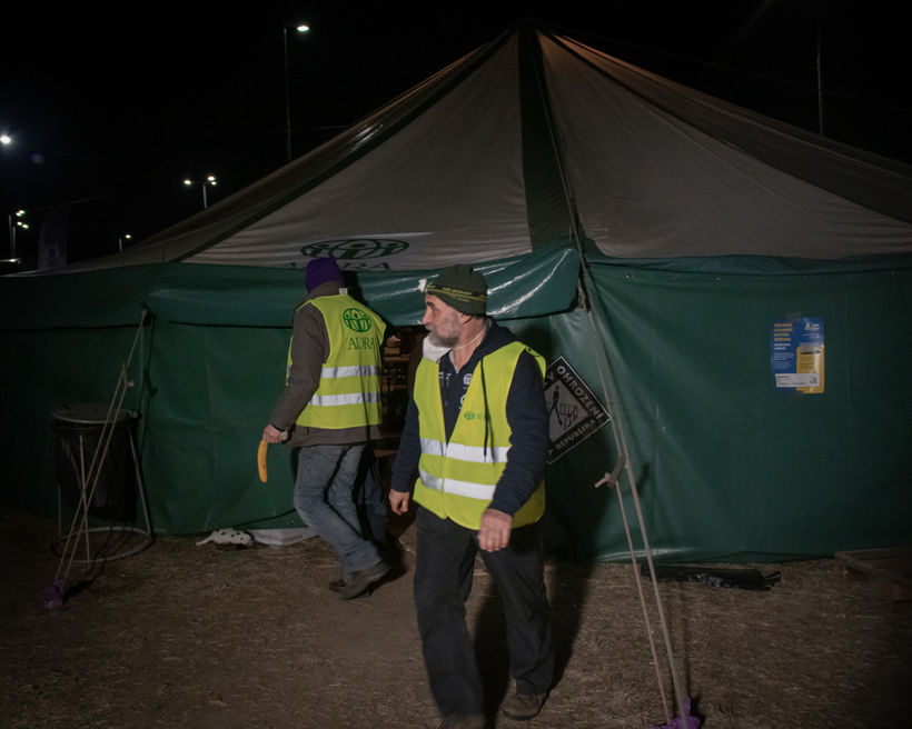 Slovakian volunteers with the Adventist Development and Relief Agency leave the tent where refugees can access electricity.