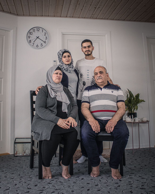 Awatif, Ahmad (sitting), and their children Maya and Mohammad pose for a photograph in the parents home.