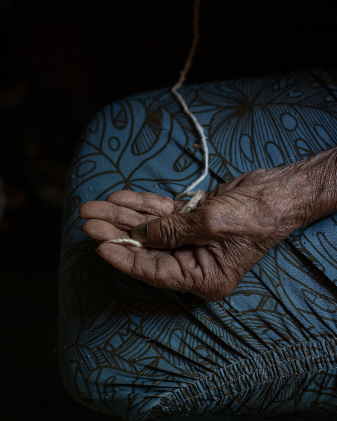 Maria Teixeira shows the string used to measure whether or not one is suffering from "espinhela caída". The same string is used in the healing process.