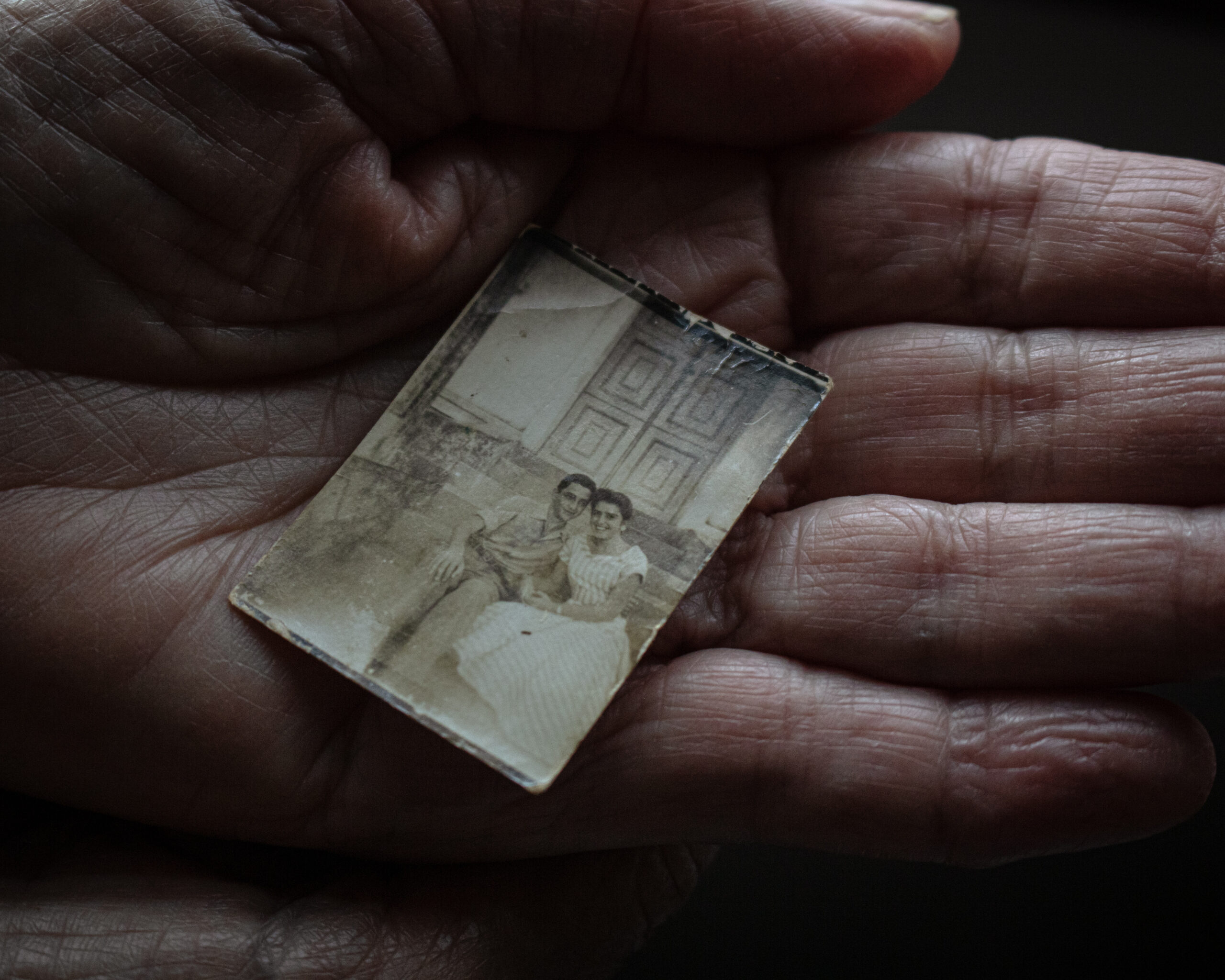 My grandmother Elvira holds in the palm of her hand a photograph of herself with my grandfather, Edivaldo, in their youth.