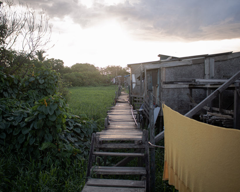 Located on municipality-owned floodplain grounds, Alvorada is home to roughly 25 Brazilian and Venezuelan families. Poorly built stilt shacks rising above ground level can be reached by a lifted footbridge so unstable it can only hold one person at a time, stepping on two planks simultaneously to avoid any breaking.
